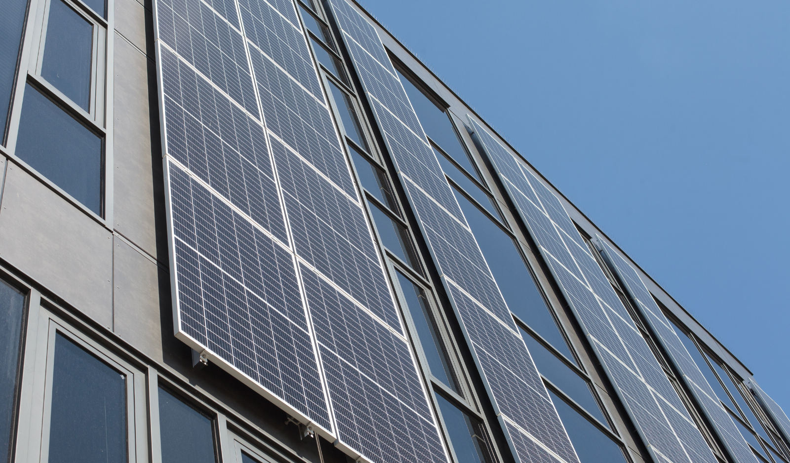 Montaj panouri fotovoltaice verticale pe fațada unei clădiri comerciale.