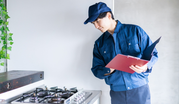 Tehnician autorizat verifică aragazul și instalația de gaze într-un apartament modern