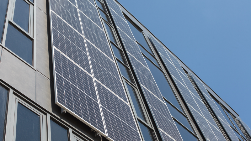 Montaj panouri fotovoltaice verticale pe fațada unei clădiri comerciale.