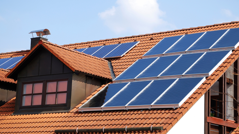 Panouri fotovoltaice montate corect pe acoperișul unei case, respectând distanțele față de coamă și ferestre