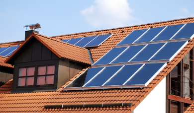 Panouri fotovoltaice montate pe un acoperiș din țiglă la o casă rezidențială.
