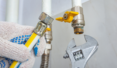 Instalator strânge racordurile instalatiei de gaz cu o cheie reglabilă în timpul reviziei