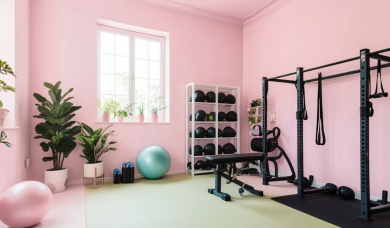 Echipamente de sală și fitness instalate acasă într-o cameră modernă, cu bancă de abdomene, greutăți și accesorii pentru antrenament.